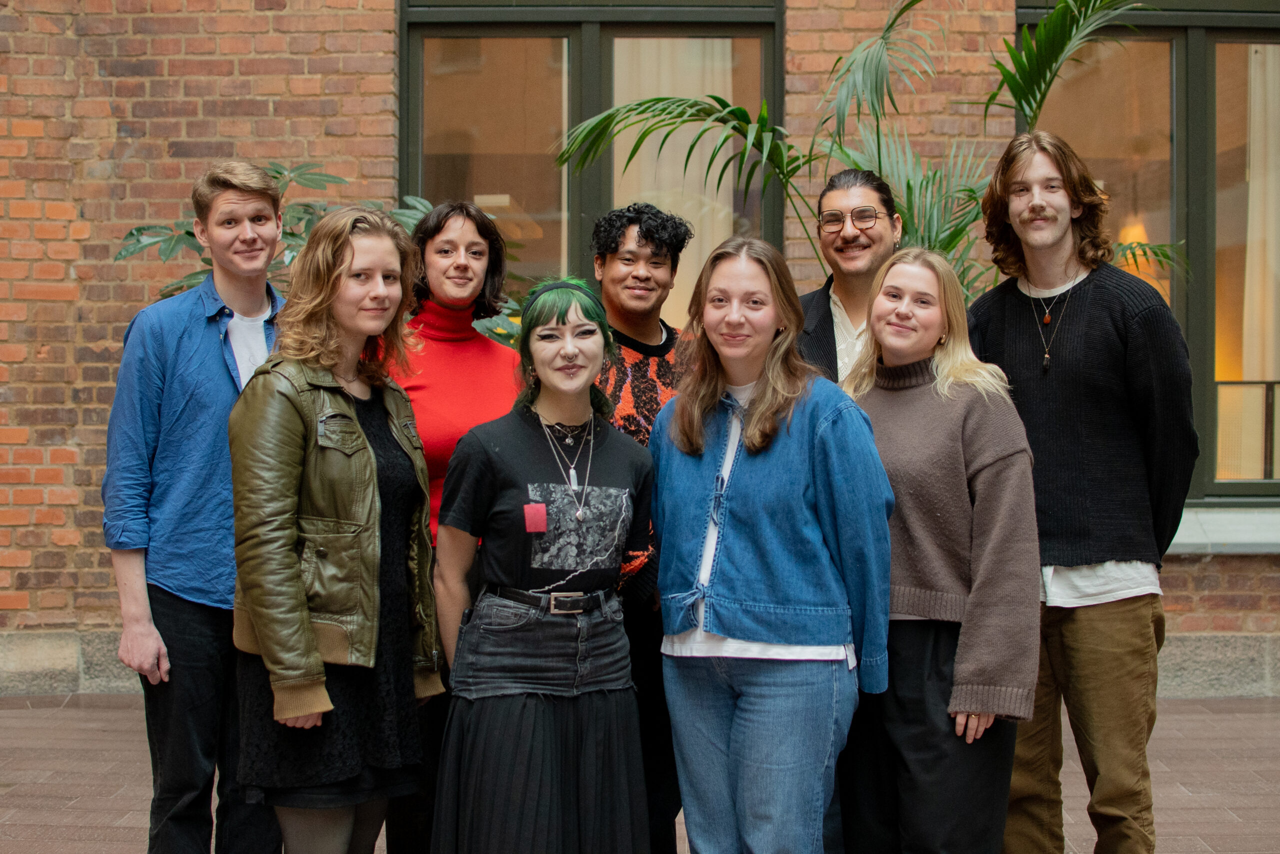 Gruppfoto på förbundsstyrelsen inomhus. Från vänster till höger står Eric, Flora, Kevin, Elias, Jakob, Frida, Max, Lina och Lydia. Alla ler in i kameran.