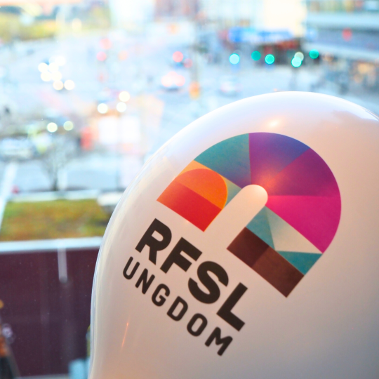 Närbild på en vit ballong med RFSL Ungdoms logga från vårt 20-årsfirande.