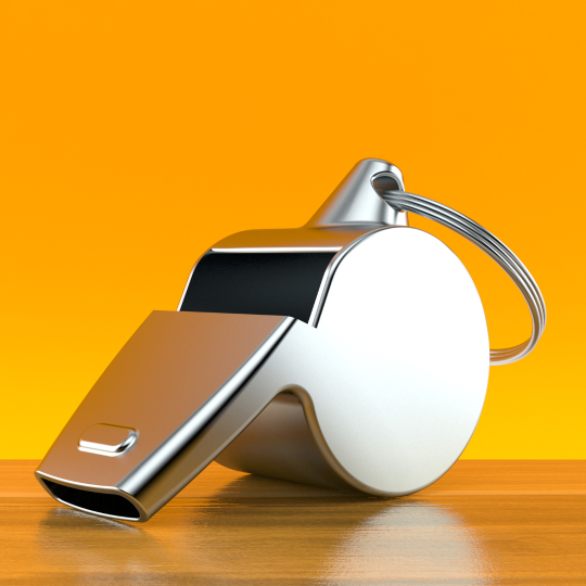 Foto på en visselpipa i polerat stål mot en orange bakgrund.